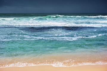 A sunny beach with palm trees on the Indian Ocean near the city of Galle in Sri Lanka.