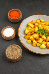 front view tasty fried potatoes inside plate with seasonings on dark desk color food kitchen photo meal