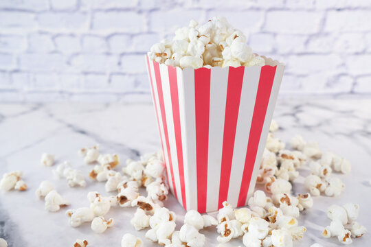  Popcorn Spilling From A Container On White Background 