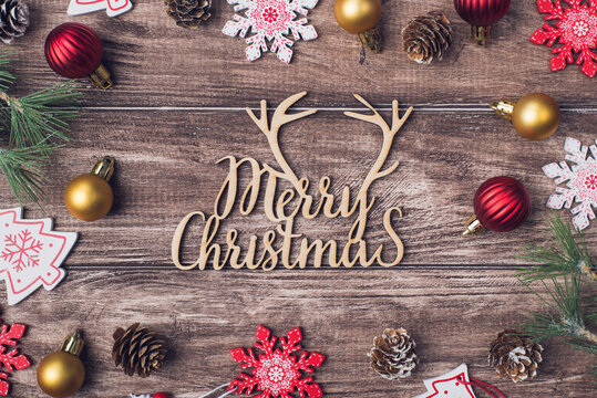 Merry Christmas congrats concept. Photo image of text with greeting and composition with evergreen accessories on wood brown desk