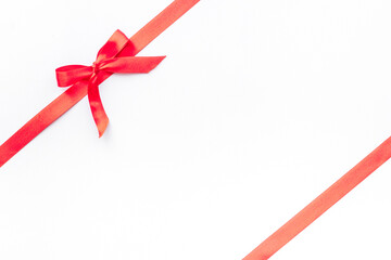 Red ribbon with bow isolated on white. Top view. Copy space