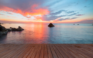 Wooden pier or jetty on a sea at amazing sunset