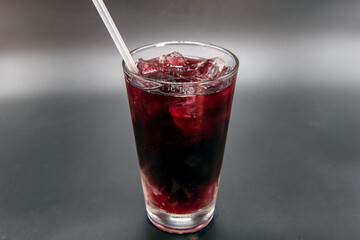 Fruity Jamaican red sweet drink flaovred with sweetness and served in a clear glass with straw to quench your thirst.
