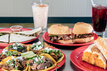 Dinner table full of meal choices of Mexican food plates seved hot and ready to eat with chilled drinks to go.