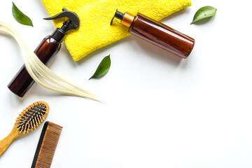 Female hair with care products and wooden comb, top view, flat lay