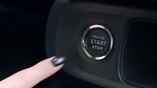The girl starts the car with the start-stop system. 4K, Slow motion, close-up
