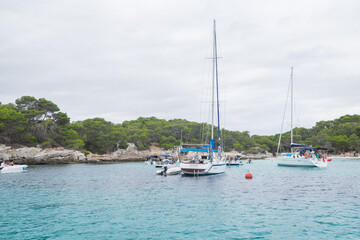 Fototapeta na wymiar Menorca, Spain - August 4, 2020: Nice bay with sailboats and yachts, Cala des Talaier, Menorca, Balearic Islands. Spain.