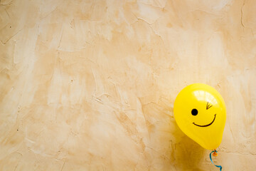 Happiness emotion face on balloon - joy mood background. Top view, copy space