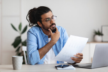 Young Arab Male Entrepreneur Working With Papers At Desk In Office