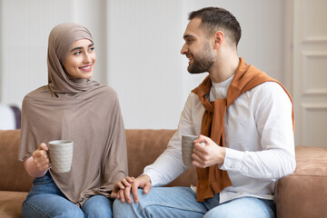 Young Muslim Couple Talking And Flirting Drinking Coffee At Home