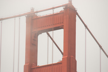 top of a tower of Golden Gate bridge in fog