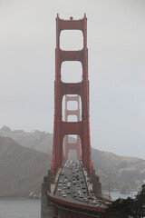 vertical photo of Golden Gate bridge in San Francisco with traffic on a cloudy day