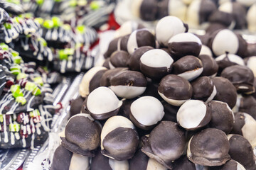 marzipan sweets covered with chocolate coating black and white closeup on a blurred dessert background