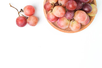 Top view of fresh grape on wooden plate isolated on a white background.