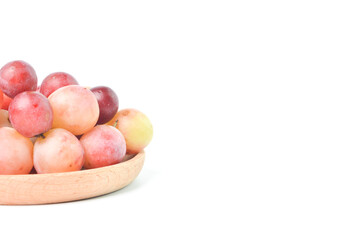 Bunch of fresh grape on wooden plate isolated on a white background.