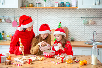 Happy family mother and daughters bake cookies for Christmas