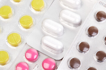 Different medicines tablets, pills in blister pack, medications drugs, macro close up in a white background
