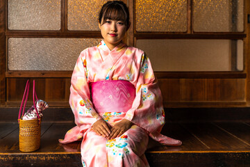 玄関土間に座る浴衣の女性