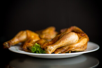 whole fried chicken in a plate on a black