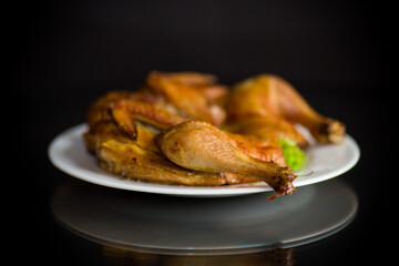 whole fried chicken in a plate on a black