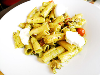 Pasta with pesto sauce and nuts on a the table
