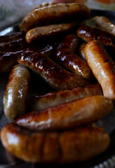Grilled barbeque sausages on plate close up, meat meal at picnic