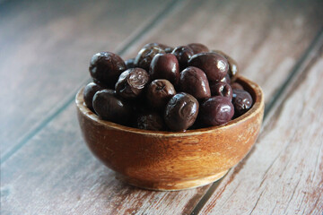 fresh natural black olives in a wooden plate