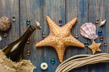Fototapeta na wymiar Sea and ocean gifts on a wooden background. Marine things. Sea products. Water Background for real man captains and sailors. Pirate design. Bottle, rope, star. Underwater treasures.