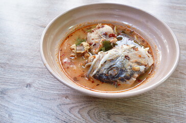 spicy boiled bass fish and head in tom yum soup on bowl