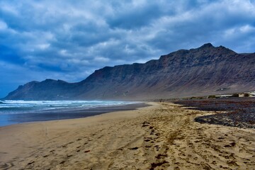 Windiger Strand mit Bergwand auf Lanzarote
