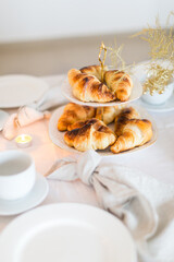 Christmas decoration of the festive table with cakes, glasses and candles