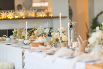 Christmas decoration of the festive table with cakes, glasses and candles