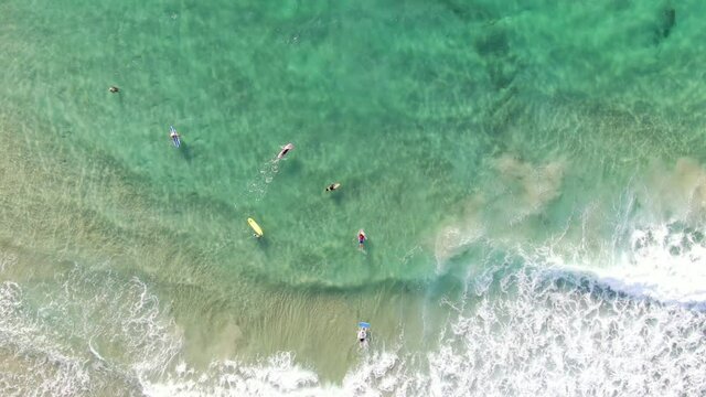 Top-down view of azure waves and surfers on the Mediterranean Sea. Netanya  Israel
