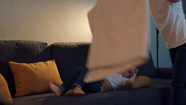 Happy family - a little boy falls asleep on the couch and his mother covers him with a blanket