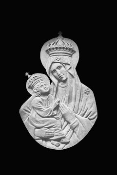Fragment of ancient statue of Virgin Mary with baby Jesus Christ. Isolated black background.