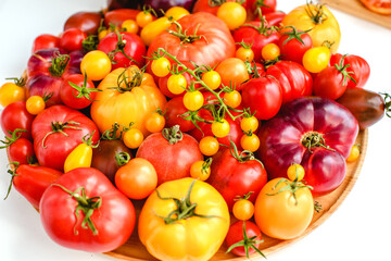 Different tomatoes on white. Vegetables of different varieties