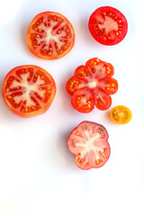 Different tomatoes on white. Vegetables of different varieties