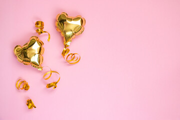 Gold balloon in the shape of a heart on a pink background. Valentine's day concept. Copy space for text.