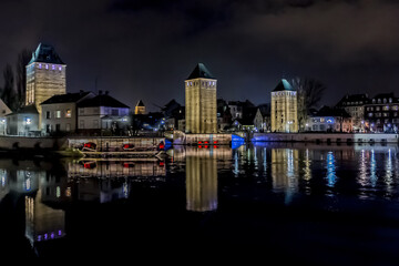 Obraz premium Night illumination of the famous medieval bridge Ponts Couverts (13th century) on the River Ill. Strasbourg, Alsace, France.