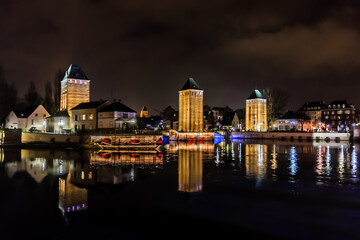 Obraz premium Night illumination of the famous medieval bridge Ponts Couverts (13th century) on the River Ill. Strasbourg, Alsace, France.