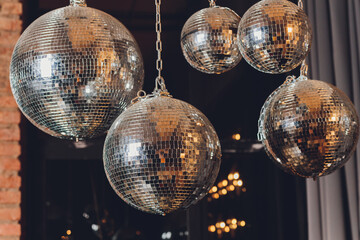 Sparkly disco ball hanging in an empty grungy room.