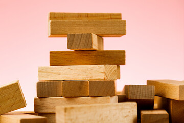 The concept of entrepreneurial risk. wooden blocks on a pink background.