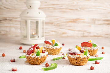 Tastyy sweet cakes for Christmas morning. Bright portioned oatmeal baskets with banana filling and fruits on the top.