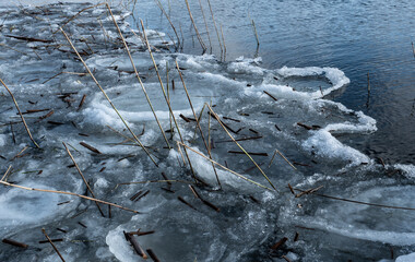 Frozen and snowy river bank in spring.