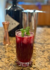 holiday red cocktail with ingredients in the background 