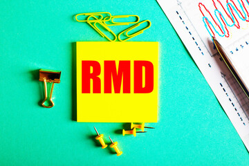 RMD is written in red on a yellow sticker on a green background near the graph and pencil