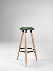 Wooden stool with leather seat on a neutral background