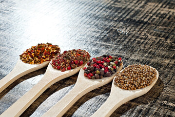 A mixture of various spices in a wooden spoon. Spices and seasonings on an old shabby board. Mix on a pile close up. Place for text and copy space near the spoon.