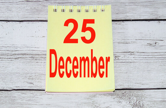 2021 written in red on a yellow sheet of notepad lying on a light wooden background, the concept of Christmas and New Year, minimalism