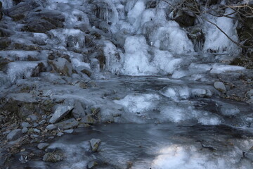 Frozen pool at the bottom of waterfalls in arctic winter; concepts of cold and peaceful
